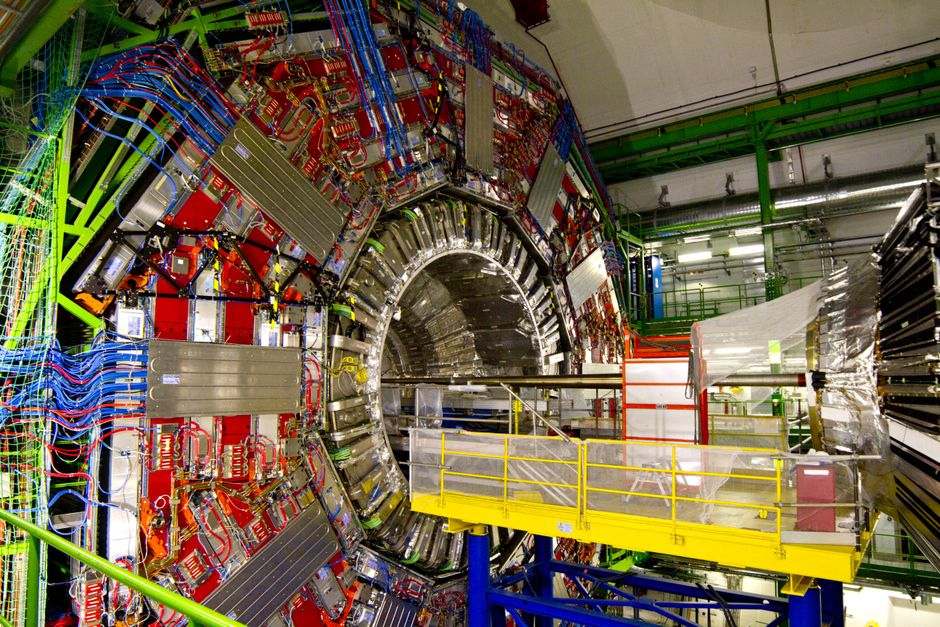 Interior of a large particle accelerator facility with cylindrical chambers and walkways