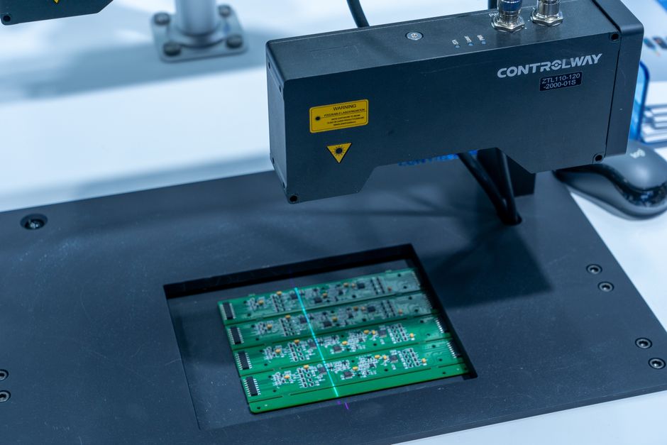 Close-up of an automated PCB inspection machine examining a printed circuit board in a manufacturing facility
