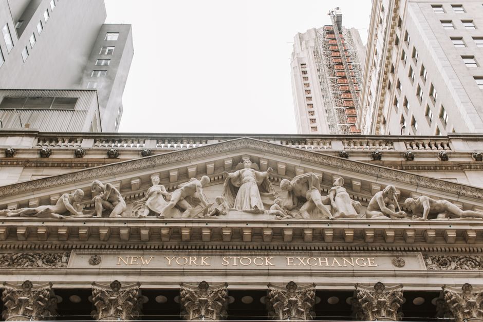 The stone facade of the New York Stock Exchange building with carved architectural reliefs.