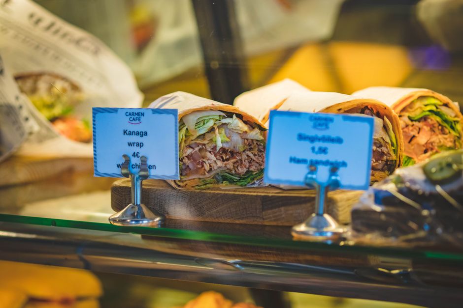 Wrapped sandwiches and food items displayed at a cafe deli counter