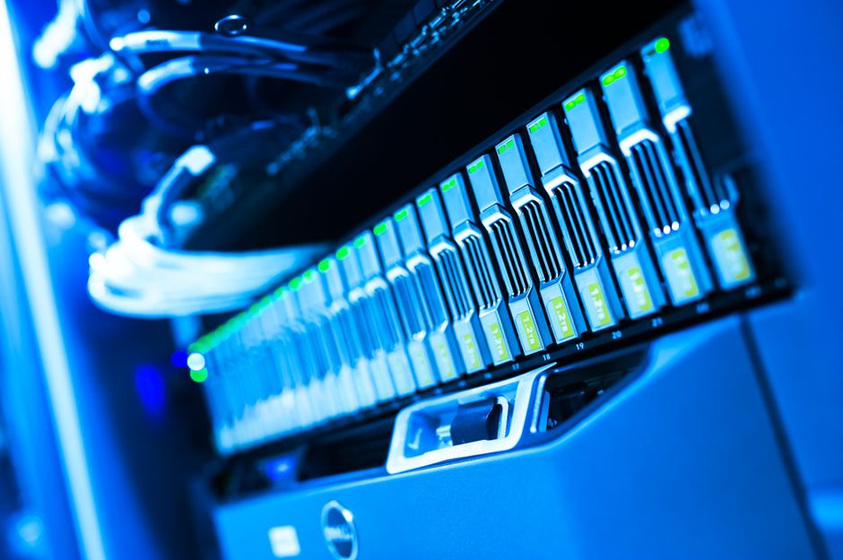 A blue-lit computer server rack in a data center, representing the AI and cloud infrastructure whose spending cycle now drives both software revenue and the 2026 IPO pipeline.