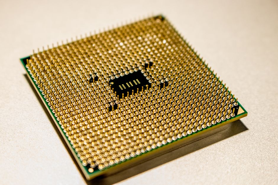 Close-up of a golden microprocessor chip on a white surface