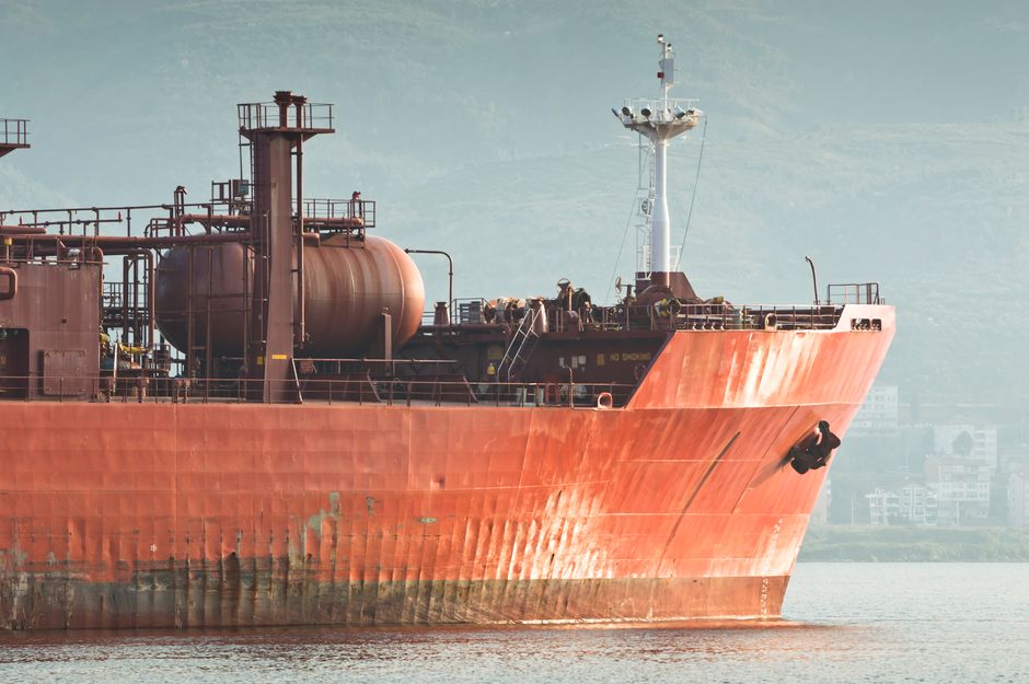 An industrial ship near a coastline representing disrupted energy flows.