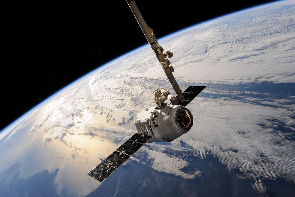 Satellite gliding over Earth with dramatic cloud formations visible below