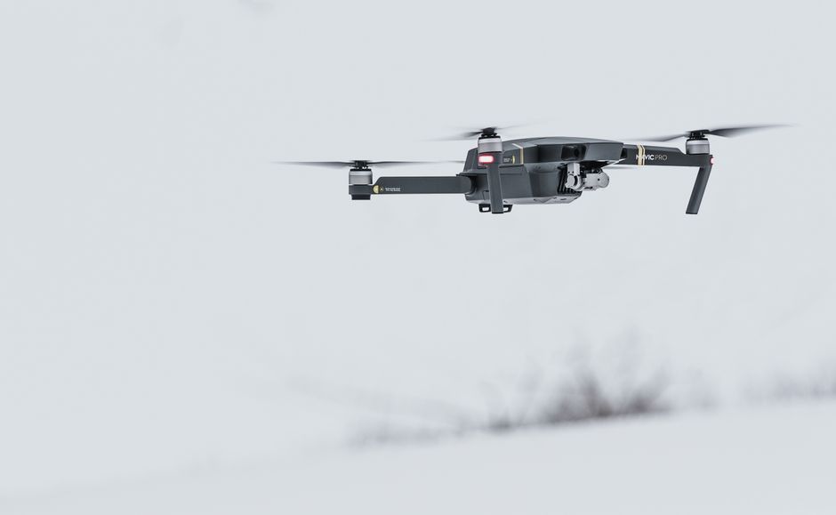 A military surveillance drone in flight against a gray sky, representing the aerial campaign reshaping energy infrastructure risk.