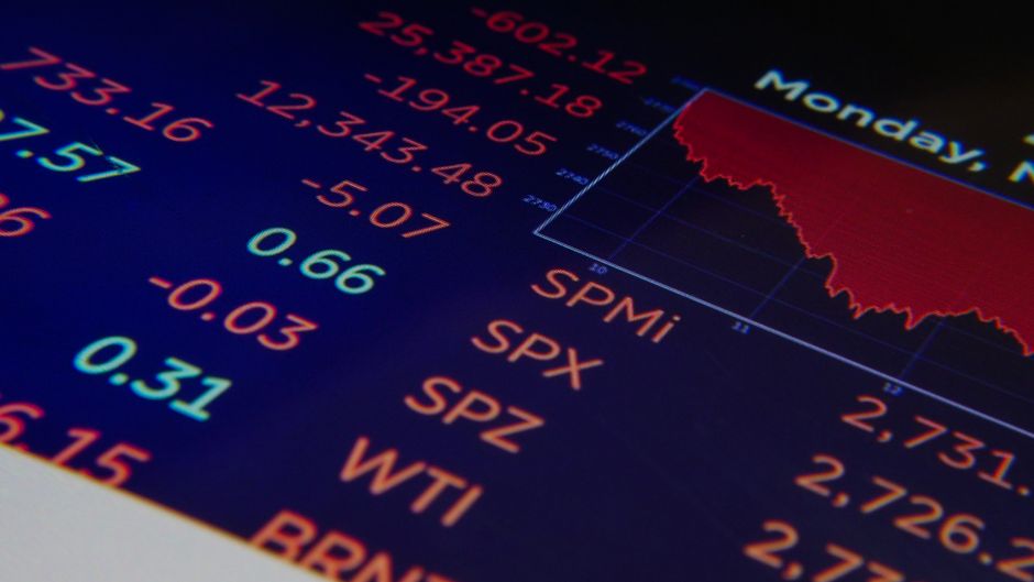 Close-up of a digital financial display showing market data and indices in blue and amber tones.