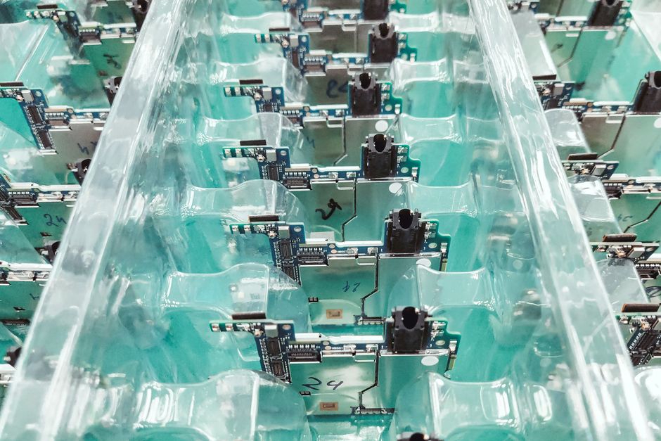 Close-up of organized electronic circuit boards in a production facility
