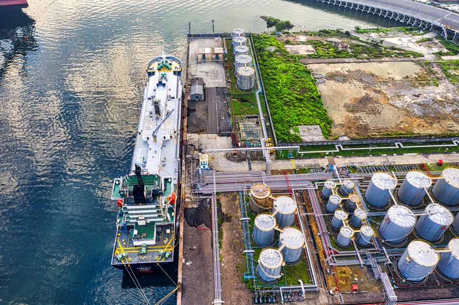 Cargo ship docking at an industrial port as energy supply constraints transmit into inflation and company margins