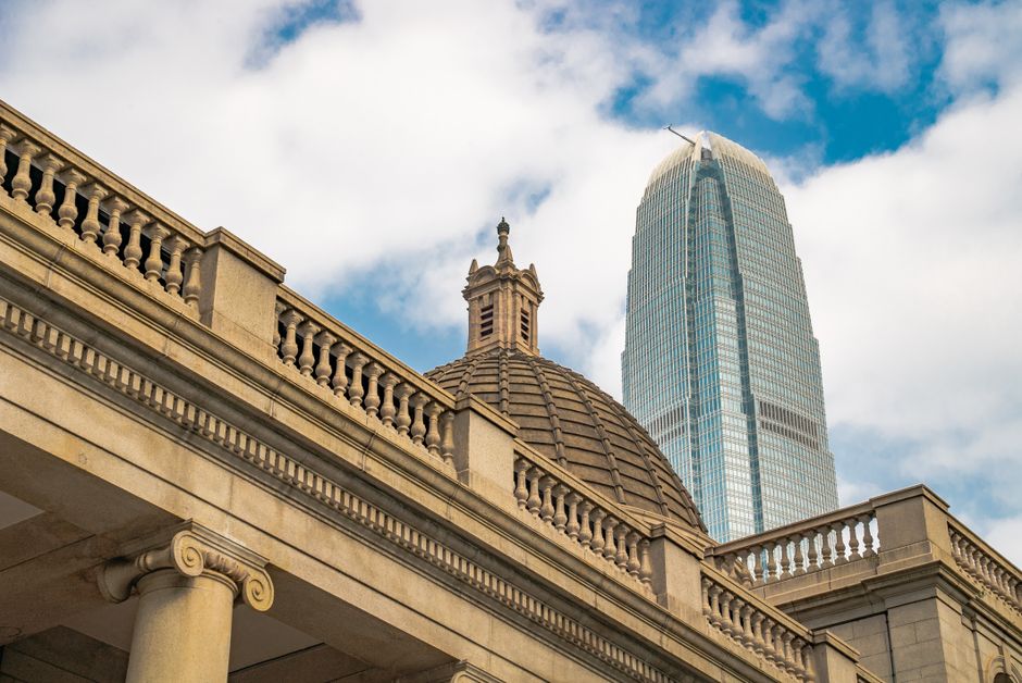 Low-angle view of Hong Kong's skyline contrasting older and modern skyscraper architecture.