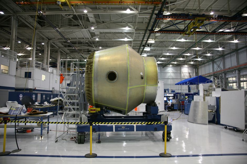 Spacecraft under assembly in a rocket factory, representing the aerospace sector's transition from private to public markets.