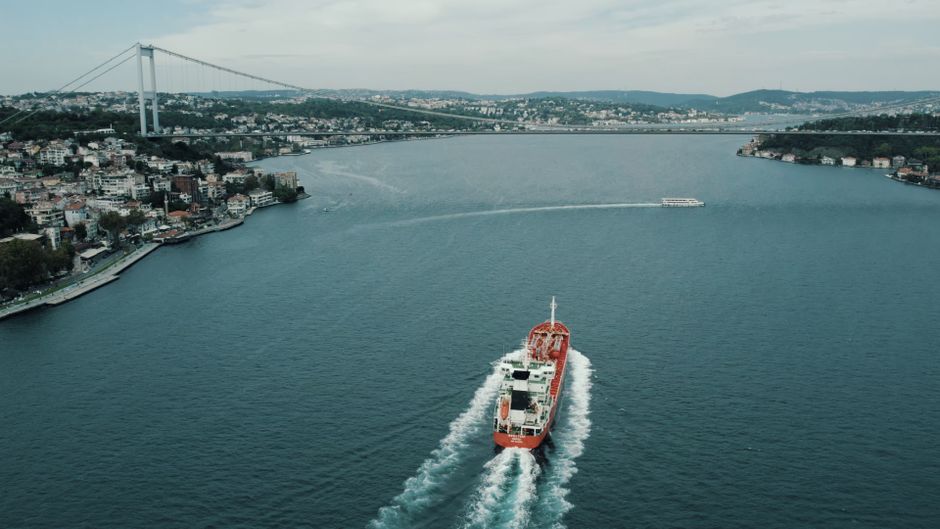 A cargo ship passes through a strategic maritime chokepoint, underscoring the shipping risk at the center of the market story.