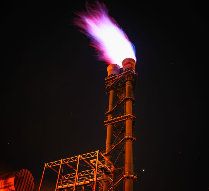 Industrial gas flare stack at night