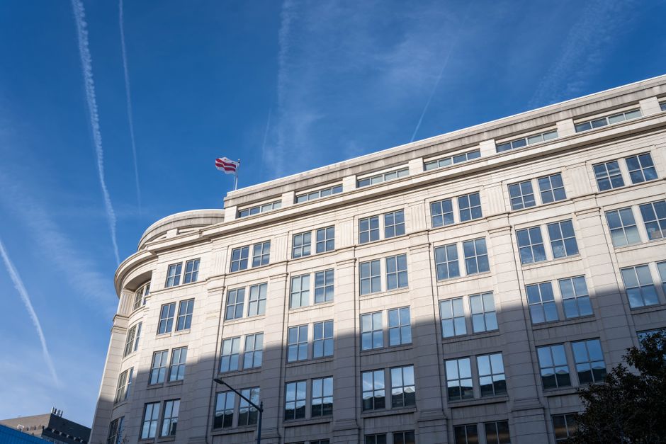 Modern office building under a clear blue sky in Washington, D.C., representing the seat of US financial regulation.
