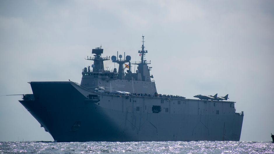 Majestic aircraft carrier sailing on the open sea under a clear sky