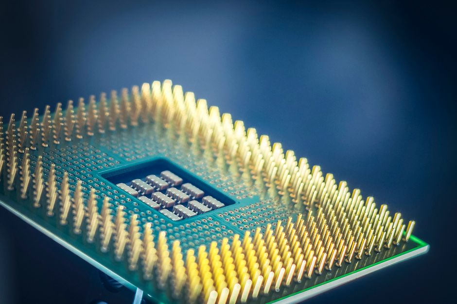 Computer processor chip with gold pins on blue background