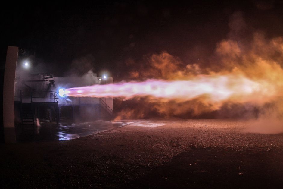 Rocket engine test firing with flames at night