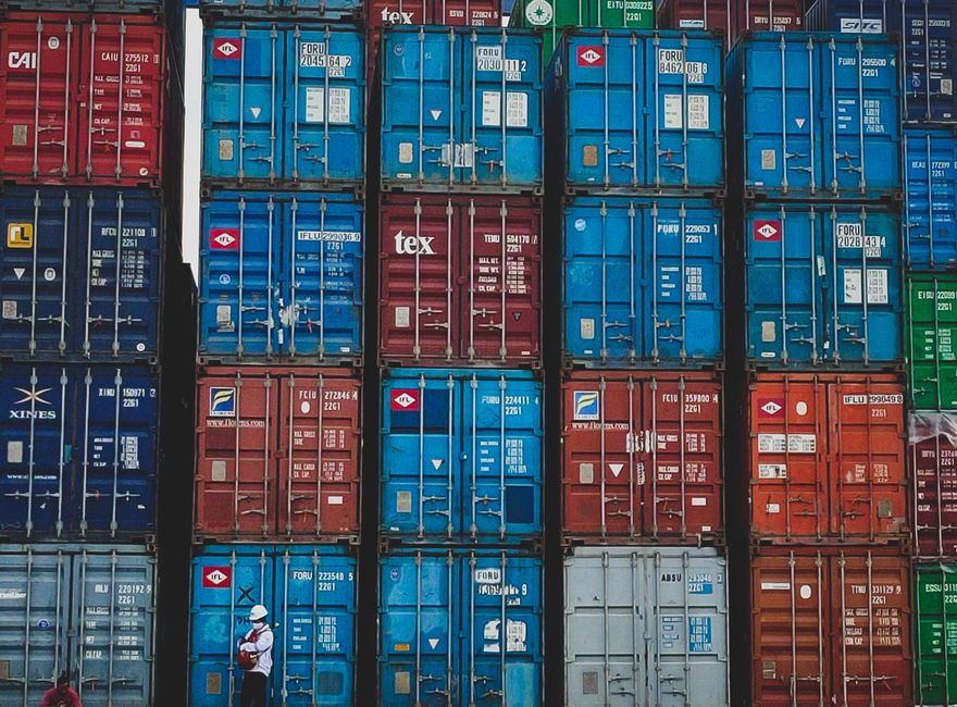 Stacked shipping containers at a busy port terminal