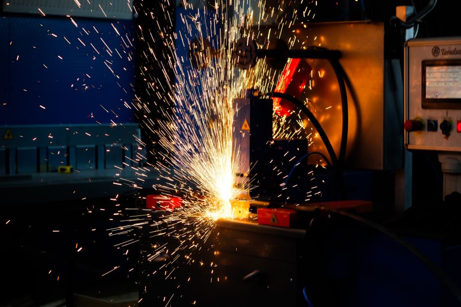 Close-up of industrial welding sparks in a manufacturing setting, highlighting precision metalworking processes.