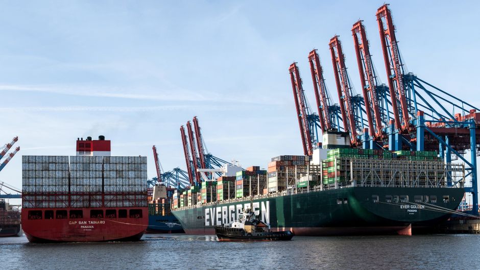 Container ships gathered at a commercial port as maritime disruption raises supply-chain risks.