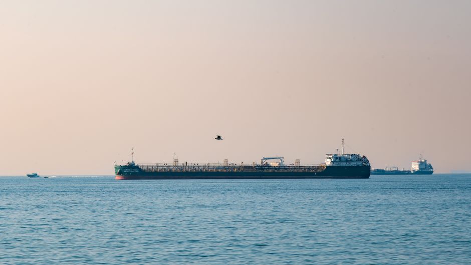 Cargo ships at sea representing the Strait of Hormuz shipping chokepoint and energy-flow risk.