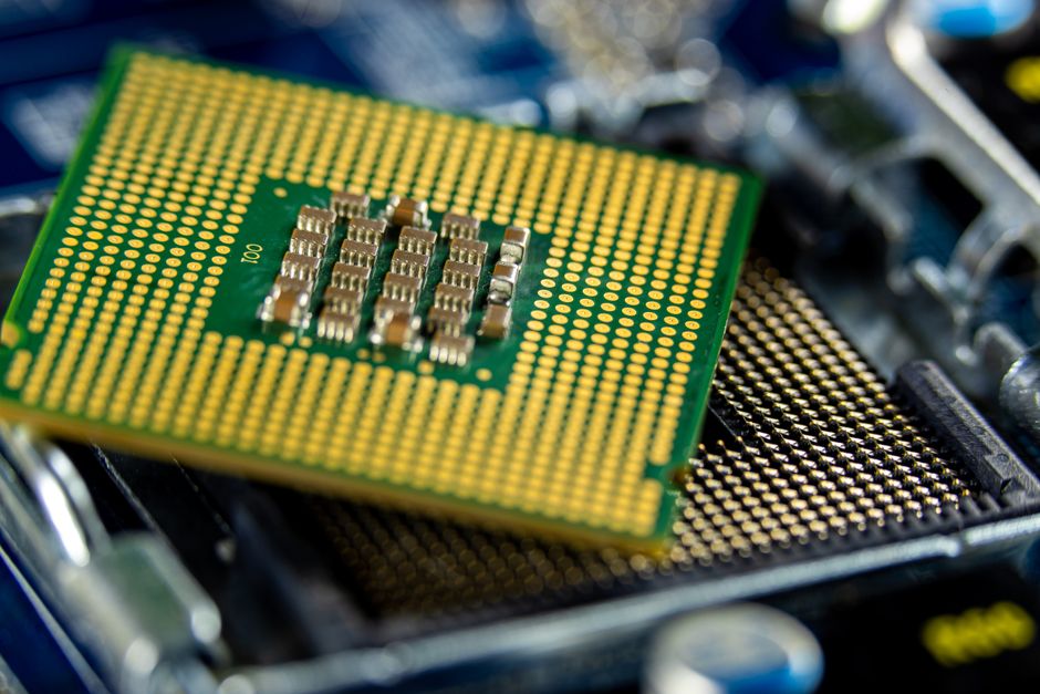 Close-up of a computer microprocessor on a motherboard, showing intricate circuitry and gold pins.