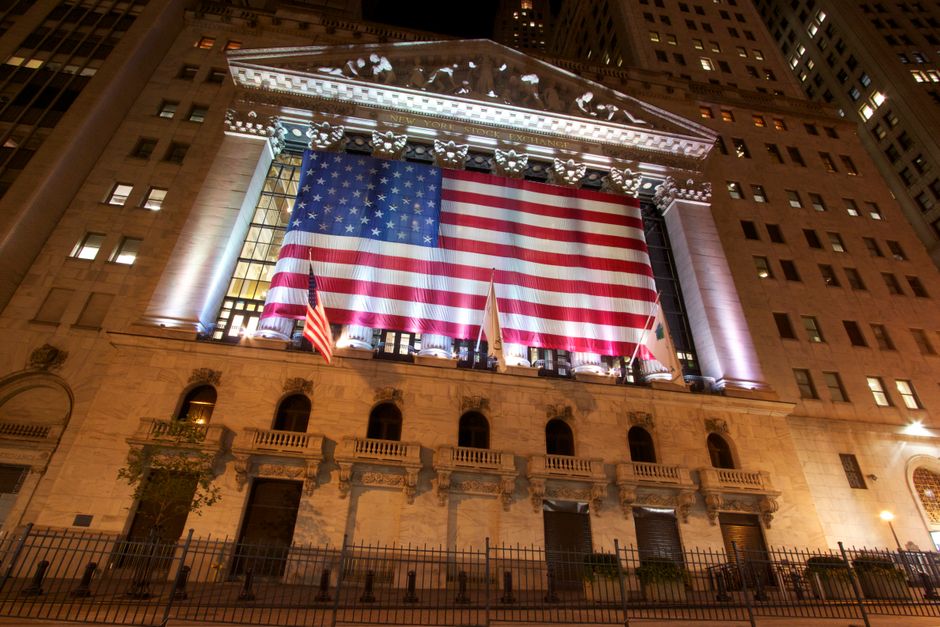 The illuminated New York Stock Exchange represents the reopened IPO market and the infrastructure needed to absorb new equity supply.