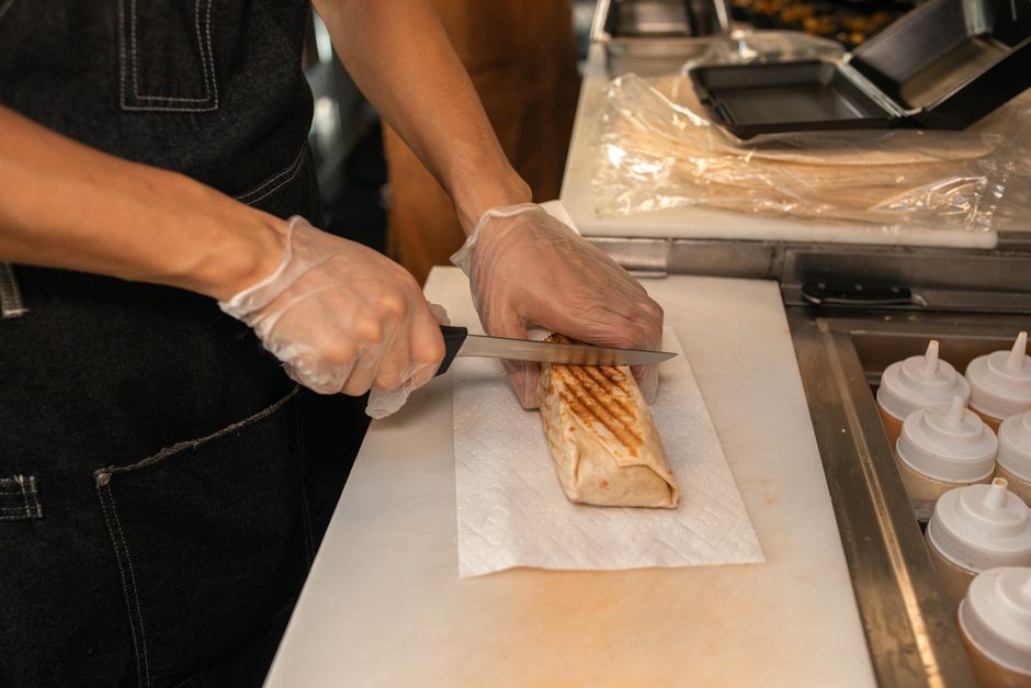 Deli food being sliced and prepared at a counter