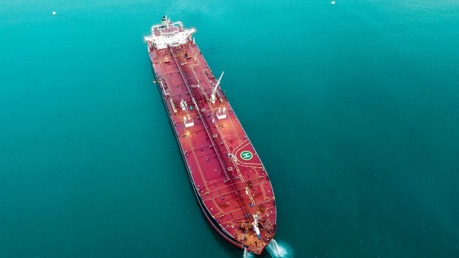 Aerial view of a large oil tanker vessel navigating open ocean, highlighting the maritime energy transport now disrupted at the Strait of Hormuz.