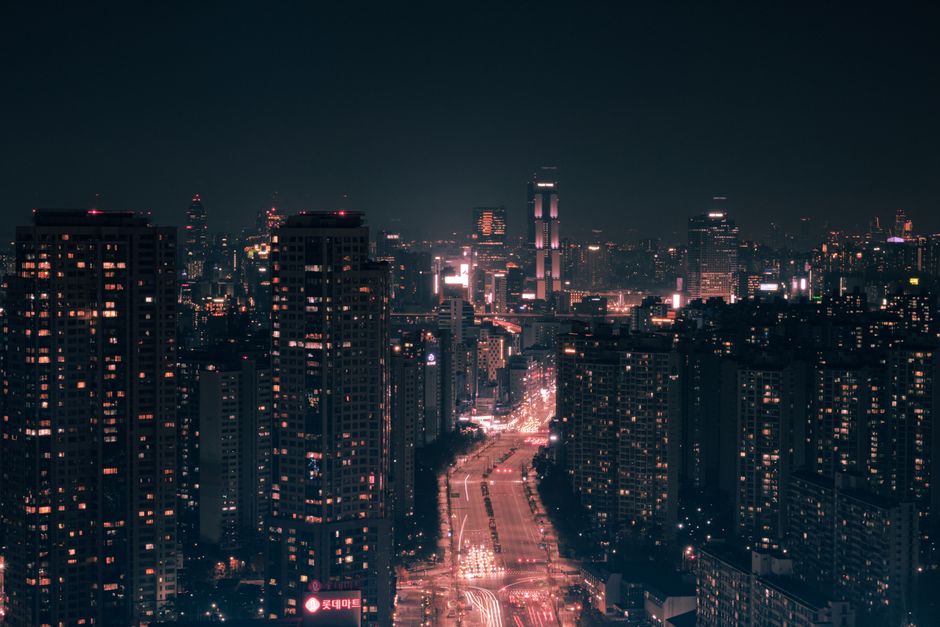 Illuminated skyscrapers of a dense urban cityscape against a dark night sky