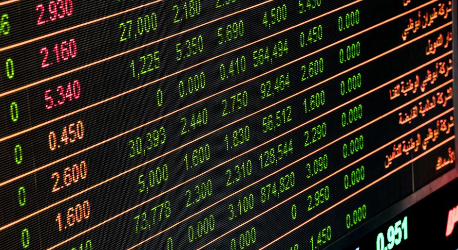 A market analyst reviews financial data on a digital trading screen.