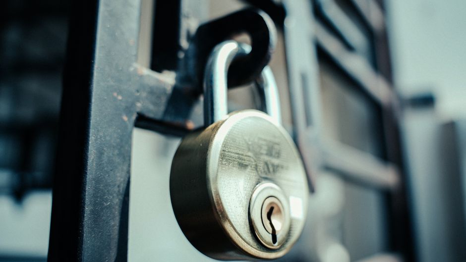 A steel padlock fastened on a gate