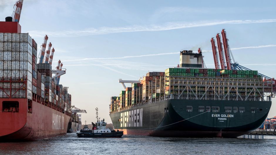 Container ships move through a commercial port as global shipping routes face disruption.