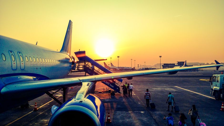 Passenger airplane at sunrise on an airport runway.