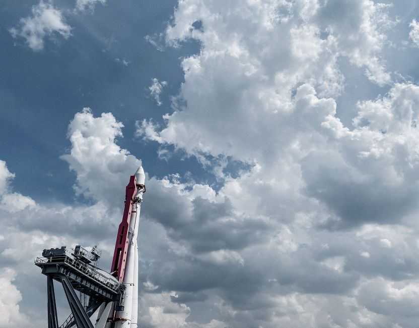 A rocket displayed against a vibrant cloudy sky, showcasing engineering and space exploration.