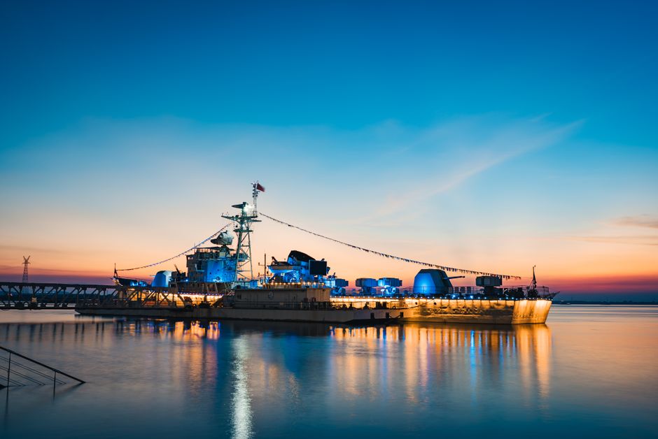 Naval warship illuminated at sunset