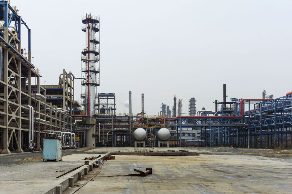 Industrial petrochemical refinery with steel pipelines, processing towers, and large structural framework