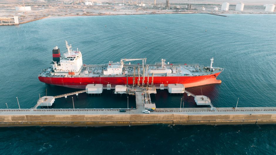 A cargo tanker docked at industrial energy infrastructure