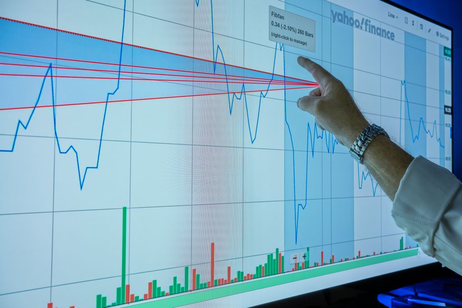 Trader examining a market chart while issuance and liquidity shape price discovery.